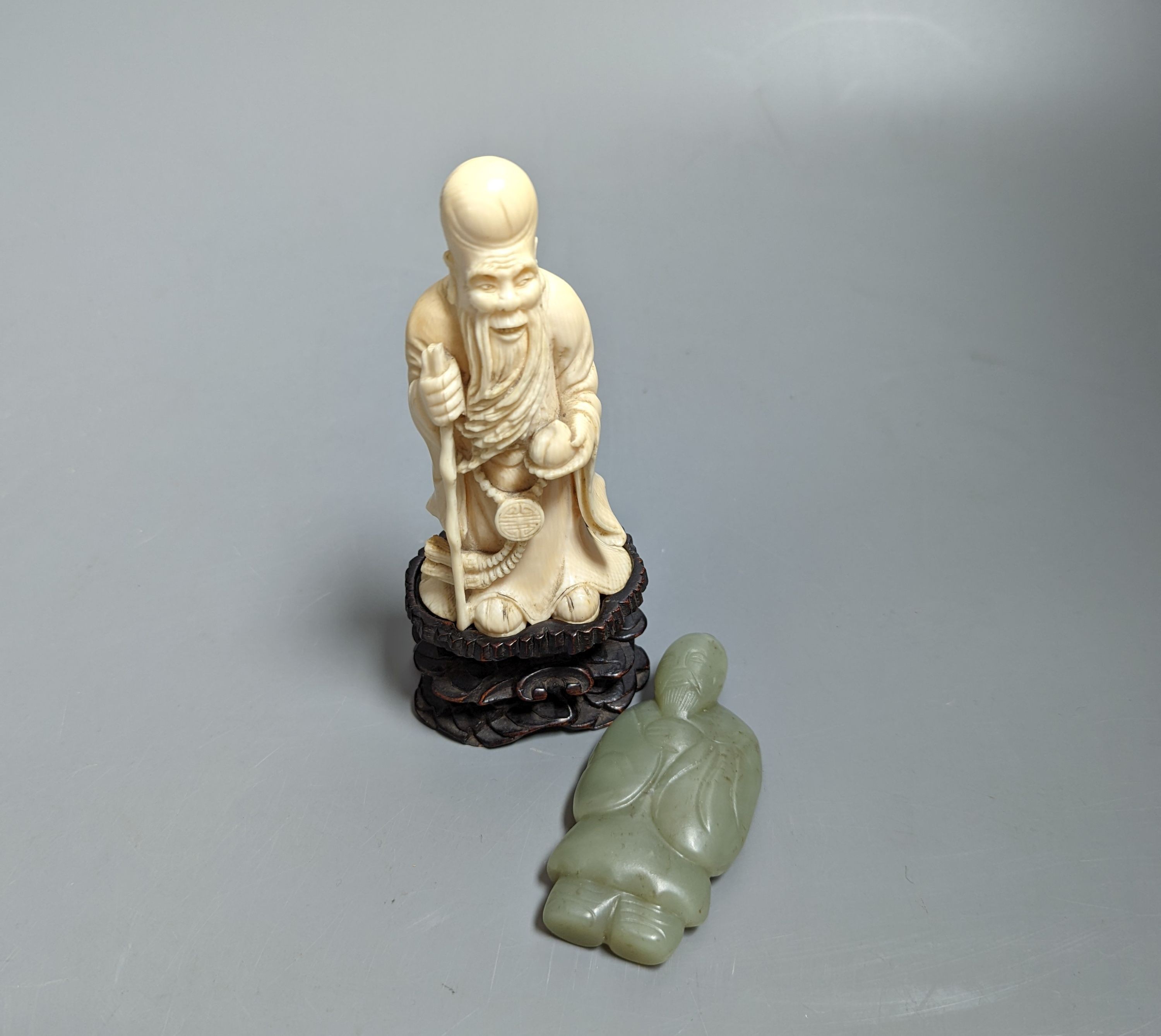 An early 20th century Chinese carved ivory figure of Shao Lao on stand and a jade figural carving 13cm